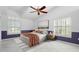 Bedroom with hardwood floors, ceiling fan, and purple walls at 6170 Misty Oaks Dr, Sarasota, FL 34243