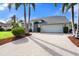 Home with a paved driveway and mature landscaping at 6170 Misty Oaks Dr, Sarasota, FL 34243