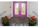 Double purple doors with glass inserts and red flowers at 6170 Misty Oaks Dr, Sarasota, FL 34243