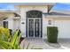 Front entrance with decorative iron gate and purple door at 6170 Misty Oaks Dr, Sarasota, FL 34243