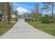 Long driveway leading to a gray house with a two-car garage at 6207 93Rd Street E Cir, Bradenton, FL 34202