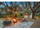 Relaxing fire pit area with seating under the shade of large trees at 6207 93Rd Street E Cir, Bradenton, FL 34202