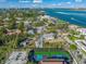 Aerial view of waterfront property with main house, guesthouse, and pickleball court at 624 Norsota Way, Sarasota, FL 34242