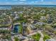 Aerial view of waterfront property with tennis court and nearby homes at 624 Norsota Way, Sarasota, FL 34242