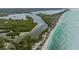 Aerial view of coastline with lush greenery and beach at 624 Norsota Way, Sarasota, FL 34242