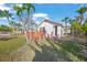 White bungalow with a deck, surrounded by tropical foliage at 624 Norsota Way, Sarasota, FL 34242