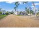 Charming bungalow style home with a gravel driveway and tropical landscaping at 624 Norsota Way, Sarasota, FL 34242