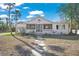 White bungalow style home with a walkway and mature palm trees at 624 Norsota Way, Sarasota, FL 34242