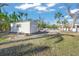 White storage shed in a yard with overgrown grass at 624 Norsota Way, Sarasota, FL 34242