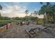 Relaxing patio with fire pit, lounge chairs, and view of golf course at 654 Trenton Way, Osprey, FL 34229