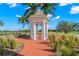 White gazebo with brick pathway, surrounded by landscaping at 654 Trenton Way, Osprey, FL 34229