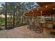 Covered outdoor kitchen with bar seating and stainless steel appliances at 654 Trenton Way, Osprey, FL 34229