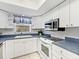 Kitchen featuring stainless steel appliances, white cabinets, and window with blinds at 6770 Mauna Loa Blvd, Sarasota, FL 34241