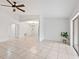 Spacious living room with tile floors, sliding glass doors and a ceiling fan at 6770 Mauna Loa Blvd, Sarasota, FL 34241