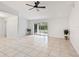 Living room with tile floors, sliding glass doors, ceiling fan, and potted plants at 6770 Mauna Loa Blvd, Sarasota, FL 34241