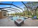 Large screened pool and spa with a fire pit and lounge chair at 6919 Winners Cir, Lakewood Ranch, FL 34202