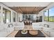 Open concept living room with white sofas and a view into the kitchen and dining areas at 7007 Point Of Rocks Rd, Sarasota, FL 34242