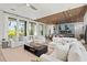 Open concept living room features white sectional sofas, a coffee table, and a view into the dining area at 7007 Point Of Rocks Rd, Sarasota, FL 34242