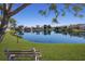 Beautiful lakefront view with a park bench, serene setting at 7203 41St E Ct, Sarasota, FL 34243