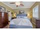 Main bedroom with a king-size bed, wood dresser, and ceiling fan at 7203 41St E Ct, Sarasota, FL 34243