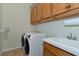 Laundry room with washer, dryer, cabinets, and utility sink at 7315 Bianco Duck Ct, Sarasota, FL 34240