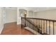 Elegant upstairs hall with hardwood floors and an ornate iron railing at 7315 Bianco Duck Ct, Sarasota, FL 34240