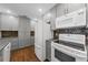 Modern kitchen with white appliances and gray cabinetry at 7460 W Country Club N Dr, Sarasota, FL 34243