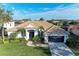 Single-story home with tile roof, lush landscaping, and a two-car garage at 7555 Tori Way, Lakewood Ranch, FL 34202