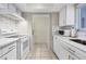 Clean and bright kitchen with white cabinets and stone backsplash at 757 Beach Rd # 208, Sarasota, FL 34242