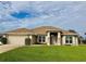 One-story home with a large front yard, attached garage, and neutral color palette at 87 Long Meadow Ln, Rotonda West, FL 33947