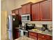 Modern kitchen with stainless steel appliances and dark wood cabinets at 87 Long Meadow Ln, Rotonda West, FL 33947