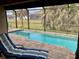 Screened pool area with lounge chairs and tranquil view at 87 Long Meadow Ln, Rotonda West, FL 33947