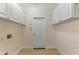 Laundry room with white cabinets and wood-look floors at 9100 Yarberry St, Sarasota, FL 34240