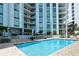 Relaxing pool area with patio furniture and building view at 1111 N Gulfstream Ave # 14C, Sarasota, FL 34236