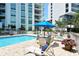 Sunny pool area with patio furniture and building view at 1111 N Gulfstream Ave # 14C, Sarasota, FL 34236