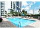 Community pool with patio furniture and building view at 1111 N Gulfstream Ave # 14C, Sarasota, FL 34236