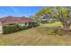 House backyard view, featuring a large tree and grassy lawn at 121 Van Dyck Dr # Dr, Nokomis, FL 34275