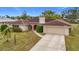 Single story home with red door and tile roof, view of driveway at 121 Van Dyck Dr, Nokomis, FL 34275