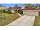 Single story home with red door and tile roof, view of driveway at 121 Van Dyck Dr, Nokomis, FL 34275