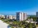 Aerial view of beachfront condo building with pool and lush landscaping at 1212 Benjamin Franklin Dr # 305, Sarasota, FL 34236