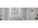 Clean and bright hallway with light teal carpet at 1212 Benjamin Franklin Dr # 305, Sarasota, FL 34236