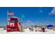 Red lifeguard stand on a beach with people enjoying the sun at 1260 Dolphin Bay Way # 303, Sarasota, FL 34242