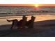 Couple relaxing on beach chairs at sunset, enjoying the ocean view at 1260 Dolphin Bay Way # 303, Sarasota, FL 34242