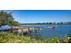 Wooden dock with boat passing by, showcasing waterfront living and boating access at 1260 Dolphin Bay Way # 303, Sarasota, FL 34242