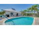 Community pool with lounge chairs and tropical landscaping at 1260 Dolphin Bay Way # 303, Sarasota, FL 34242