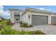 Single-story home with gray garage door and paved walkway at 12649 Palatka Dr, Venice, FL 34293