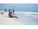 Couple relaxing on Siesta Key beach, enjoying the sun and ocean view at 1280 Dolphin Bay Way # 202, Sarasota, FL 34242