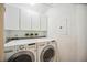 Bright laundry room with washer, dryer, and ample cabinet space at 1280 Dolphin Bay Way # 202, Sarasota, FL 34242