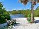 Serene waterfront view with sandy beach and wooden bench at 1314 64Th W St, Bradenton, FL 34209