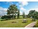 Landscaped backyard with cornhole and seating area overlooking golf course at 13947 Messina Loop, Bradenton, FL 34211